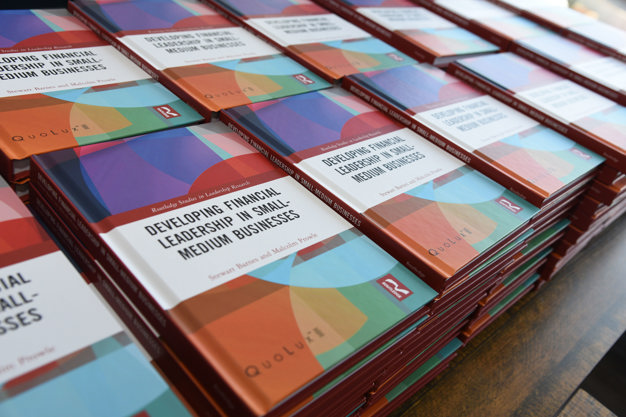rows of the Developing Financial Leadership in Small-Medium Businesses book ready to gift to guests on arrival